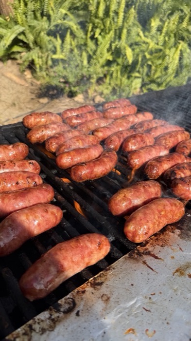 Brazilian pork sausages searing on the grill