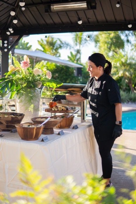 Styled catering buffet table with fresh flowers at an outdoor event