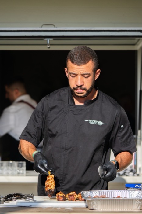 Stick'n'Bite chef in branded coat working the grill