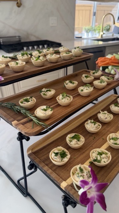 Chicken salad bites in pastry cups arranged on tiered wooden boards