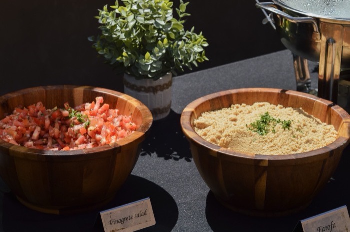Bowls of farofa and vinagrete salad with labels