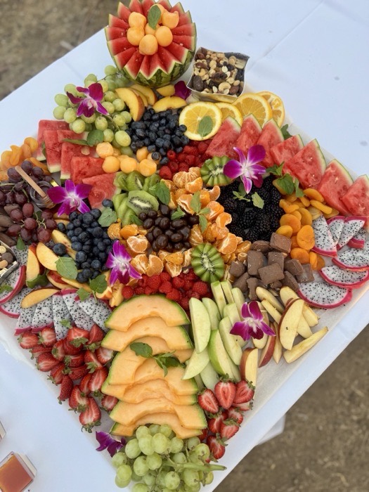Colourful seasonal fruit board with melon, berries and edible flowers